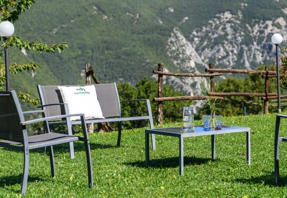 Zona relax esterna con tavolino e sedute sul prato con vista sulle montagne - Acquanera	Outdoor seating area on the lawn with mountain view - Acquanera
