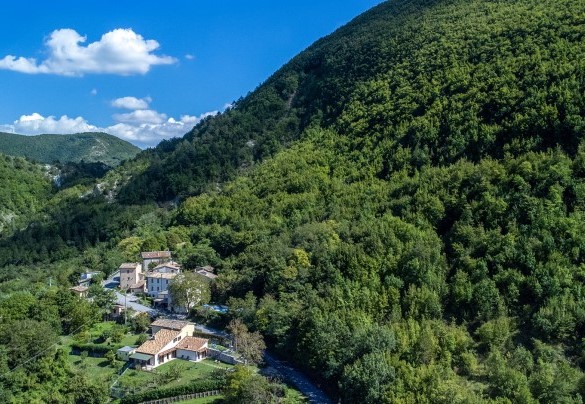 Aerial view of the village and villa surrounded by natural landscape - Acquanera