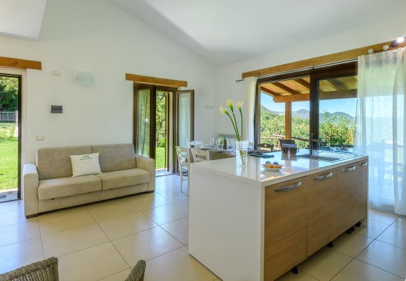 Living area with open kitchen and direct access to the garden - Acquanera