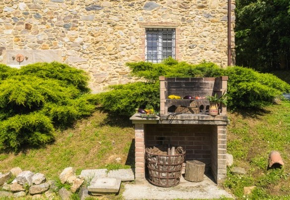 Il barbeque fisso con una aiuola di erbe aromatiche è posizionato tra la casa e la piscina - Ai due Cuori