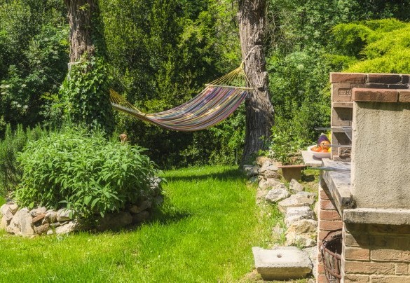 Il barbeque fisso con una aiuola di erbe aromatiche è posizionato tra la casa e la piscina - Ai due Cuori