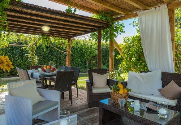 On a side of the house is a wooden gazebo set up with a confortable sitting area - Albachiara 
