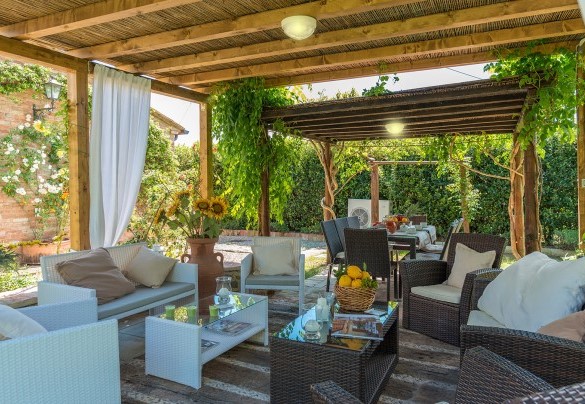 The outdoor dining area, set up with table, chairs, sofas and armchairs - Albachiara