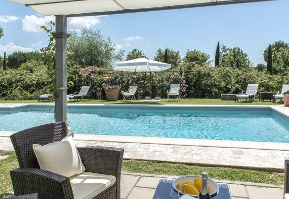 The gazebo in iron covered with climbing roses, set up as a small lounge with 4 armchairs and a coffee table - Albachiara 