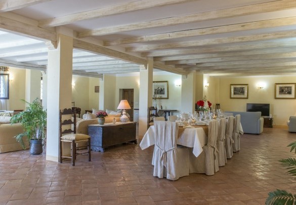 L'ampio salone al piano terra arredato con divani e grande tavolo in legno - Antiche Pietre   