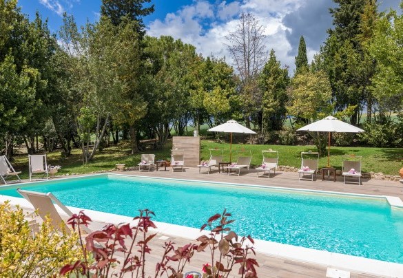 La piscina abbracciata da alberi da alto fusto - Borgo dei Cipressi  