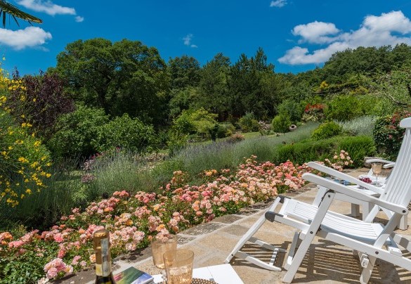 An area paved in stone, delimited by flowers, contains a cosy lounge corner – Borgo Paradiso