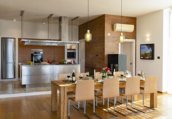 Il living con la tavola imbandita e la cucina - Brightline Villa
