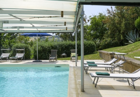 Zona piscina con lettini e copertura – Ca Lucciola