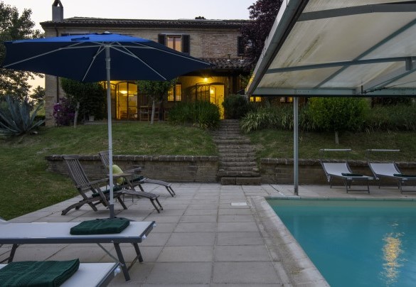 Piscina e area esterna illuminate al tramonto – Ca Lucciola