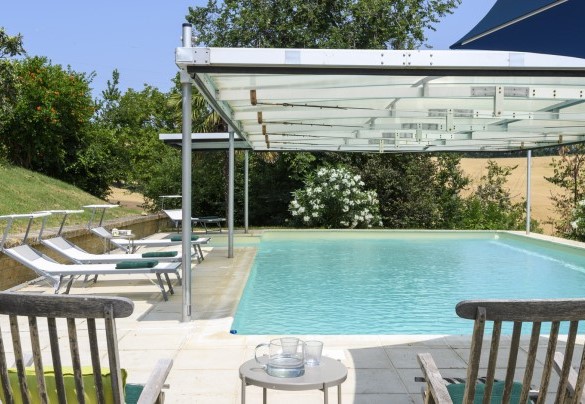 Piscina con area solarium e sedie a sdraio – Ca Lucciola
