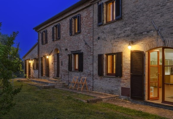 Facciata in mattoni illuminata di sera – Ca Lucciola
