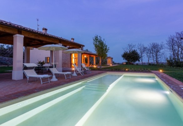 Swimming pool with solarium area equipped with sunbeds and umbrellas – Ca’ Pellicciano