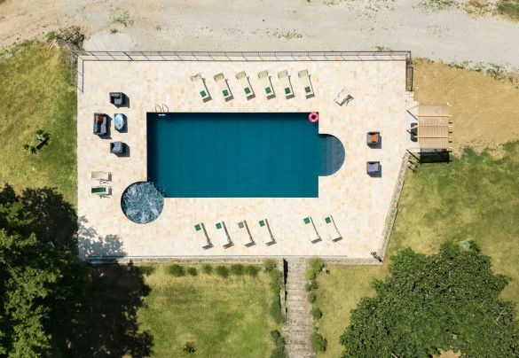 View of the swimming pool with hydromassage corner and sun loungers, surrounded by the large garden - Ca Quattrocchi