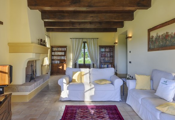 Living room with exposed beams, masonry fireplace and bookcases - Ca Seppe