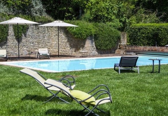 Pool with sun loungers and umbrellas, surrounded by stone walls and greenery - Ca Seppe