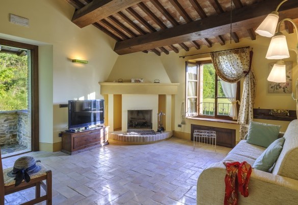 Small living room with wooden beams, fireplace and garden view - Ca Seppe