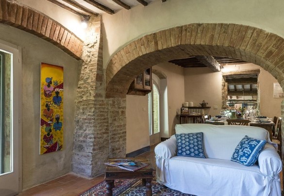 Il salotto al piano terra con tv e caminetto, comunicante con la cucina   –  Campodalto 
