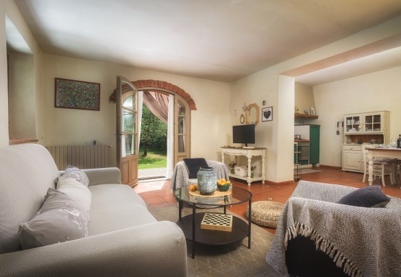 L’ingresso al piano terra conduce, tramite porta finestra, direttamente alla zona giorno dove in un unico spazioso ambiente si concentrano il salotto, con stufa a legna, divano letto e smart tv , e la cucina con zona pranzo - Casa al fiume