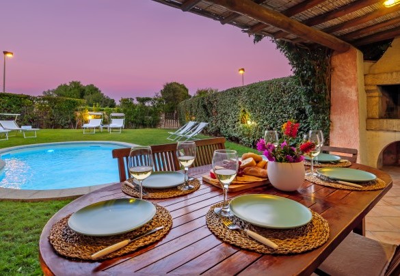 La veranda coperta, direttamente collegata con la zona giorno della casa, è arredata con un tavolo da pranzo ed è servita da un barbecue in muratura – Casa Maestrale