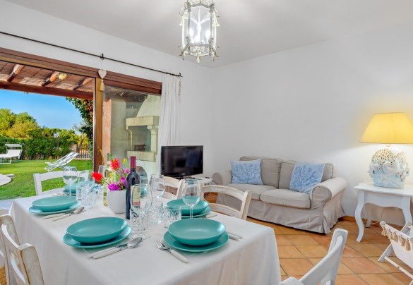 Zona giorno composta da un luminoso open space con sala pranzo e soggiorno con vista sul giardino e sulla piscina - Casa Maestrale