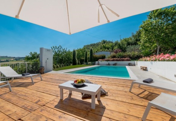 Zona prendisole in legno che avvolge la piscina - Casa Angela 6