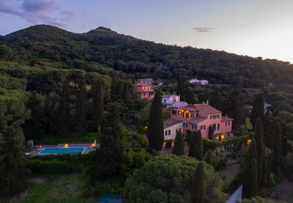 La villa, avvolta dal verde parco che la circonda, al tramonto - Casa del Duca