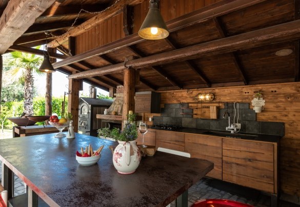 Bellissima pergola in legno con cucina all’aperto e dotata di barbecue fissi per godere appieno della vita all’aperto – Casa di Pali’