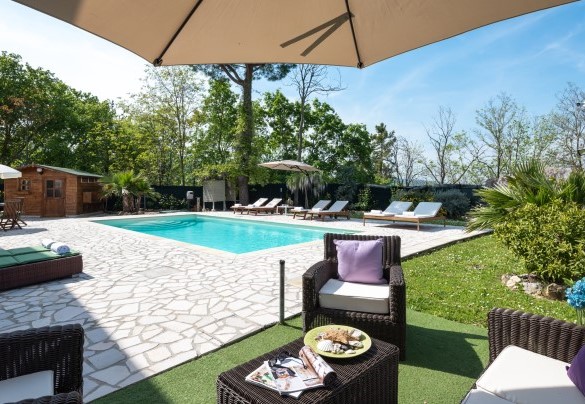 Solarium arredato con lettini, ombrellone e divanetti con tavolo - Casa di Pali’