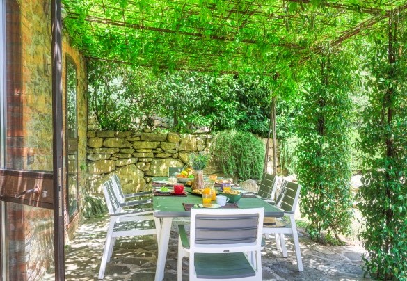 The ground-floor portico is set up with a large table, chairs and a built-in barbecue - Casa di Pan  