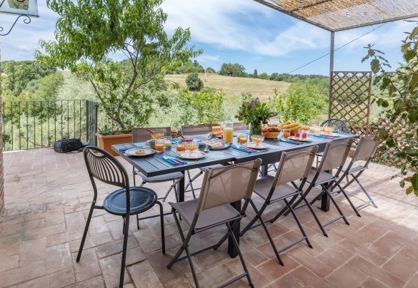 The outdoor dining area under the pergola, set up with table and chairs - Casa Eusebia