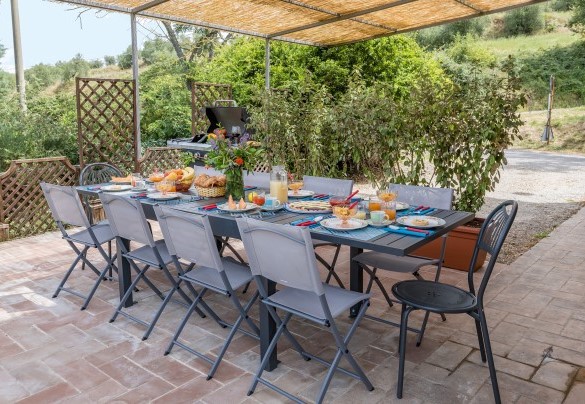 The pergola shades the table prepared for outdoor breakfasts - Casa Eusebia   