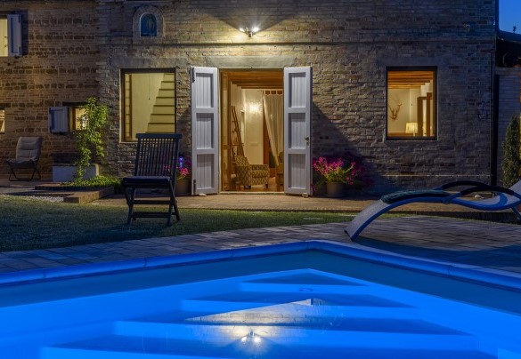 Ingresso della casa con luci serali e piscina illuminata - Casa Felicità