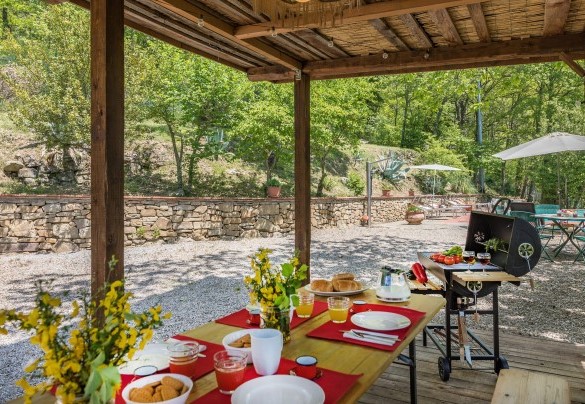 The outdoor dining area with table, benches and barbecue - Casa Largnano