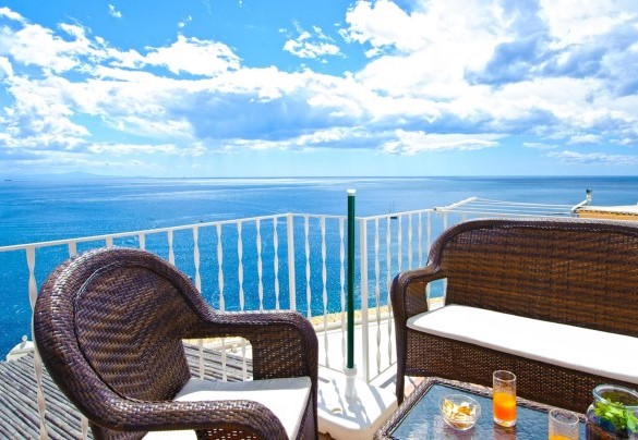 The large terrace is equipped with table, chairs, umbrella and outdoor living area – Casa Leonilde 4