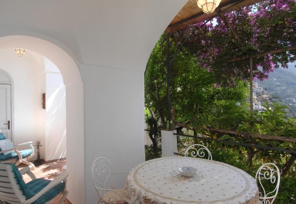 The second terrace on the lower level with the view partially covered by plants and is furnished with a comfortable dining table – Casa Maria 6+2