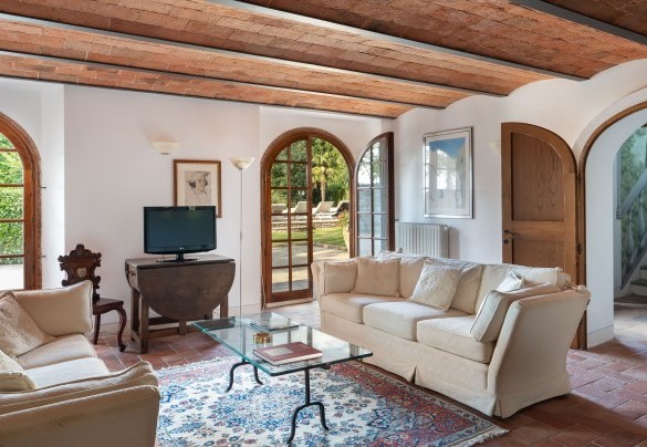 Il salone TV con camino (ornamentale), che accede al giardino tramite porte finestre al piano seminterrato – Casa Paggetti
