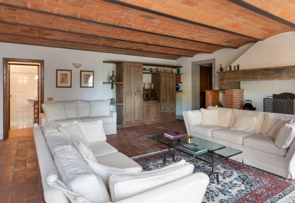 Il salone TV con camino (ornamentale), che accede al giardino tramite porte finestre al piano seminterrato – Casa Paggetti