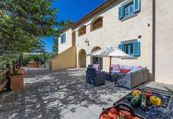 Ampia terrazza pavimentata dotata di divanetti, barbecue e zona pranzo ombreggiata da pergola - Casa Pippin
