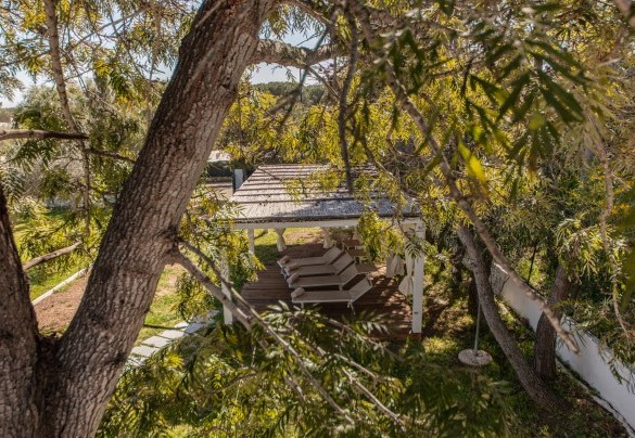 Un gazebo in legno arricchito da tende dai colori coloniali, diventa protagonista di una zona d’ombra in cui potersi rilassare durante le lunghe giornate estive – Casa Valentina