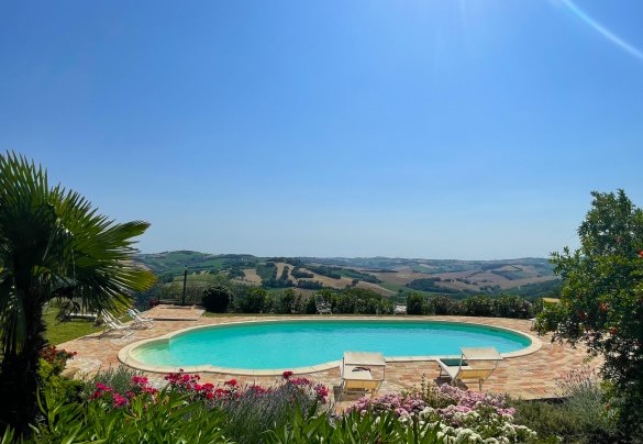 Pool overlooking the hills, surrounded by blooms and vegetation - Casa Zefiro
