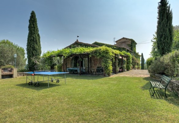 Il giardino curato con il barbecue in muratura, la pergola con la zona pranzo esterna e il ping pong – Casabianca