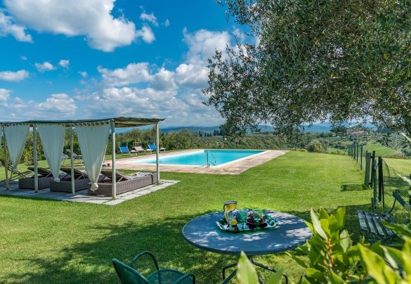 La piscina panoramica sulle colline toscane con il solarium in pietra naturale porosa – Casabianca