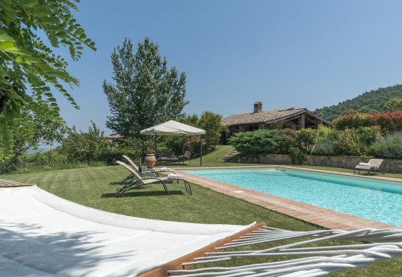 Il giardino curato, la piscina e la casa sullo sfondo - Casale al Doglio 