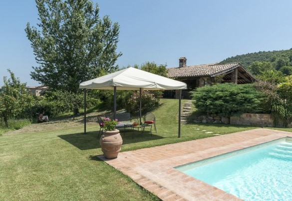 La piscina con il gazebo attrezzato e il casale sullo sfondo - Casale al Doglio 