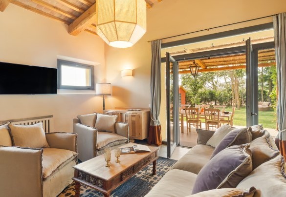 The large living room with living area, Smart TV, ornamental fireplace and exit to the pergola used as an outdoor dining area - Casale Ansedonia