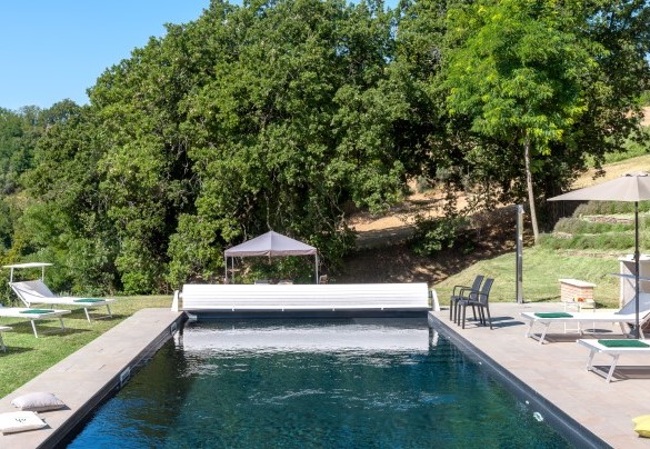 Sunbeds and solarium on the edge of the elegant dark-bottomed pool - Casale Astralis