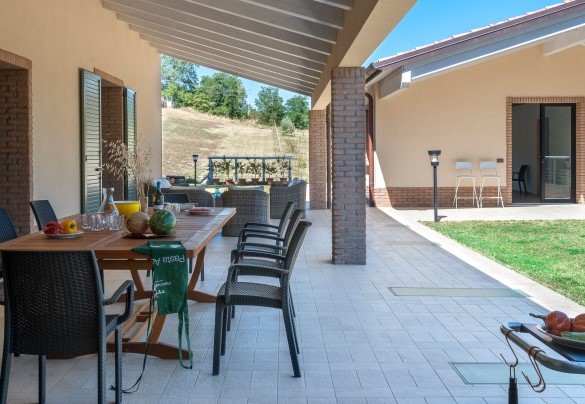 The large porch is furnished with a dining area/BBQ and with comfortable sofas - Casale Astralis