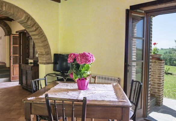 Un arco in mattoni divide il salone dalla sala da pranzo, collegata a sua volta con la cucina - Casale Cinque Valli