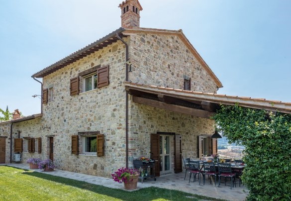 La villa e l'ampio porticato con tettoia di travi in legno arredato con sedie e tavolo - Casale dei Gelsomini 